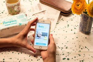 Frau mit Handy testet die neue Pampers-App