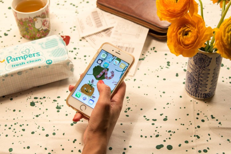 Frau mit Handy testet die neue Pampers-App