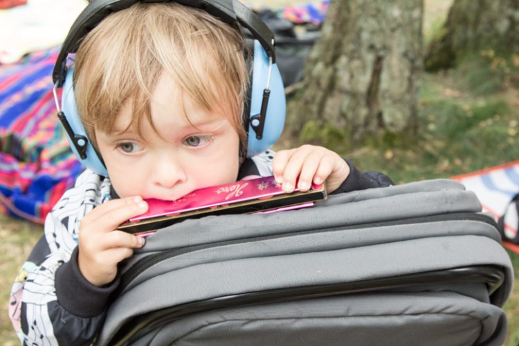 A Summers Tale-Festival mit Kind: Kind spielt Mundharmonika