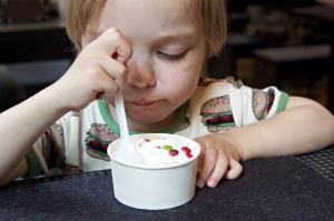 Kind ist frozn Yoghurt im Burger-Grill Peter Pane