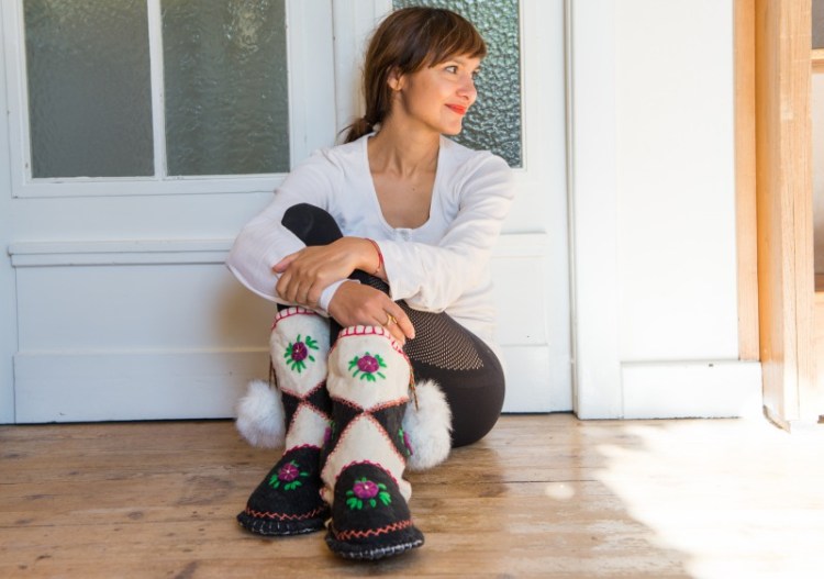 Frau trägt handgemachte Hausschuhe (Stiefel) von Woolenstocks mit Pompoms