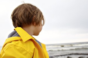 Kind in gelber Regenjacke von Petit Bateau in Binz auf Rügen