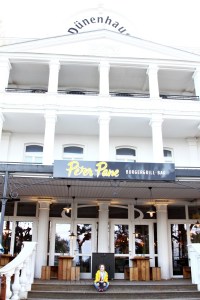 Kind sitzt vor dem Dünenhaus in Binz/ Peter Pane Restaurant Rügen