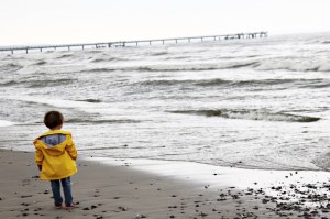 Kind in gelber Regenjacke von Petit Bateau am Strand in Binz auf Rügen