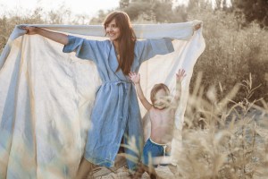 Frau mit Bademantel und Tuch aus Leinen von Kaisu Mari, kleiner Junge i Badehose von Sunuva über Nickis.com