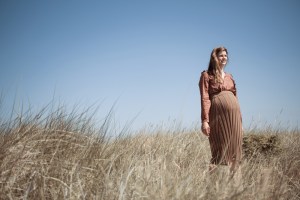 Schwangere Frau trägt Strickrock von Karin Fraidenraij und Bluse mit Rüschen von Lanius