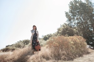 Frau im Trenchcoat und Wickelkleid von Aremed Angels zum Thema nachhaltige Mode, dazu eine Tasche von Planet Hiitu