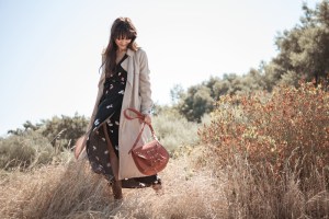 Frau im Trenchcoat und Wickelkleid von Aremed Angels zum Thema nachhaltige Mode, dazu eine Tasche von Planet Hiitu