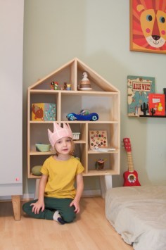 Kinderzimmer Makeover mit Wayfair: Kind sitzt vor Spielzeugregal aus Holz