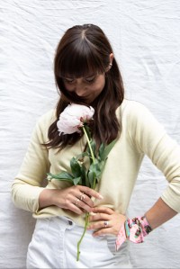 nachhaltiges Kaschmir von Peter Hahn: Frau trägt einen vanillefarbenen Kaschmirpullover, Schmuck und Vintage-Shorts